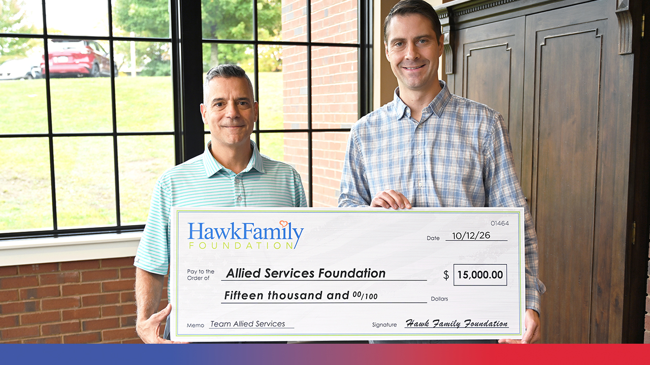 two men holding large check